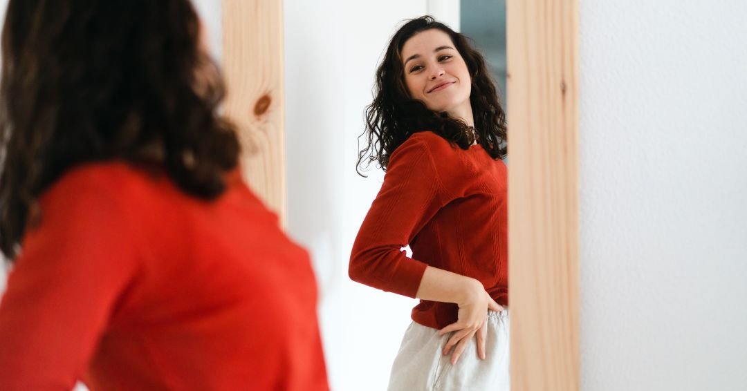 Mujer bonita viendose en un espejo con total seguridad